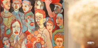 Zajrzyj w głąb siebie. Śniadanie z artystą Tomaszem Tajakiem w Galerii JDK Malarstwo ekspresjonistyczne przedstawiające stłoczony, barwny tłum postaci o wyrazistych, zniekształconych twarzach.