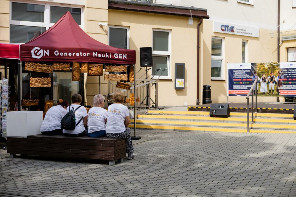 uczestnicy wydarzenia siedzący na ławeczkach