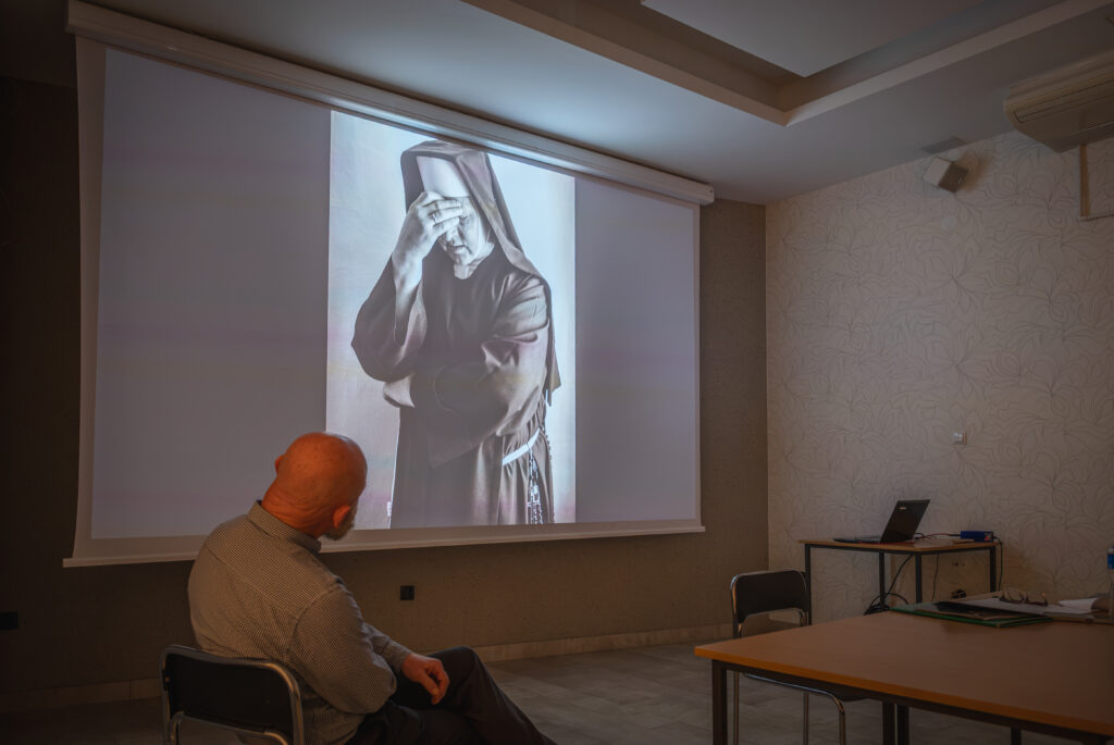 autor fotografii, a w tle wyświetlone zdjęcie zakonnicy